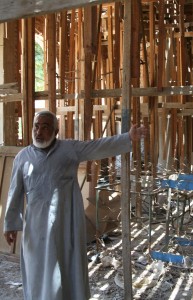 Egyptian clergyman amid church building damaged in Islamist attack. (Morning Star News photo)