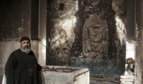 Priest examining damaged church building in Minya Governorate, Egypt. (Watani)