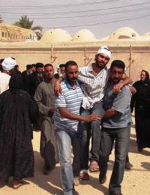 Christians assist a wounded Copt in Al Dabaya outside Luxor, Upper Egypt. (Morning Star News photo)