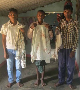 Irma Markami and his sons with bloodied and torn clothing. (Morning Star News)
