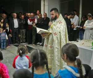 A priest conducts mass for displaced people in office complex in Erbil, Iraq. (Morning Star News)