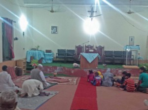 Christians look on as Muslims carry out ritual prayer after council meeting over blasphemy accusation in church building. (Morning Star News)