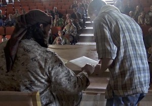Islamic State member gives Dhimma (second-class) contracts for Christians to sign. (Islamic State)