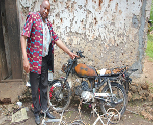 Pastor Damson Maonesho and damaged motorbike near Zanzibar City. (Morning Star News)
