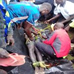 Area residents untie the body of Dante Tambika on shore of Lake Lemwa, Uganda on Sept. 1, 2021. (Morning Star News)