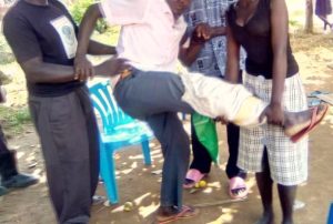 Neighbors help Tambuze Marijani of Nangi village, Uganda after relatives beat him on Jan. 4, 2024. (Morning Star News)