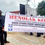 Muslim residents with banner saying they reject construction of Catholic church building in Cipamokolan village, Indonesia. (Porosmedia.com)