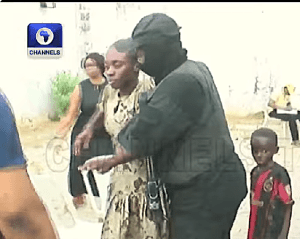 Security personnel escort one of 38 released Christians following their Nov. 21, 2025 kidnapping in Eruku village, Kwara state, Nigeria. (Screenshot from Channels TV video)